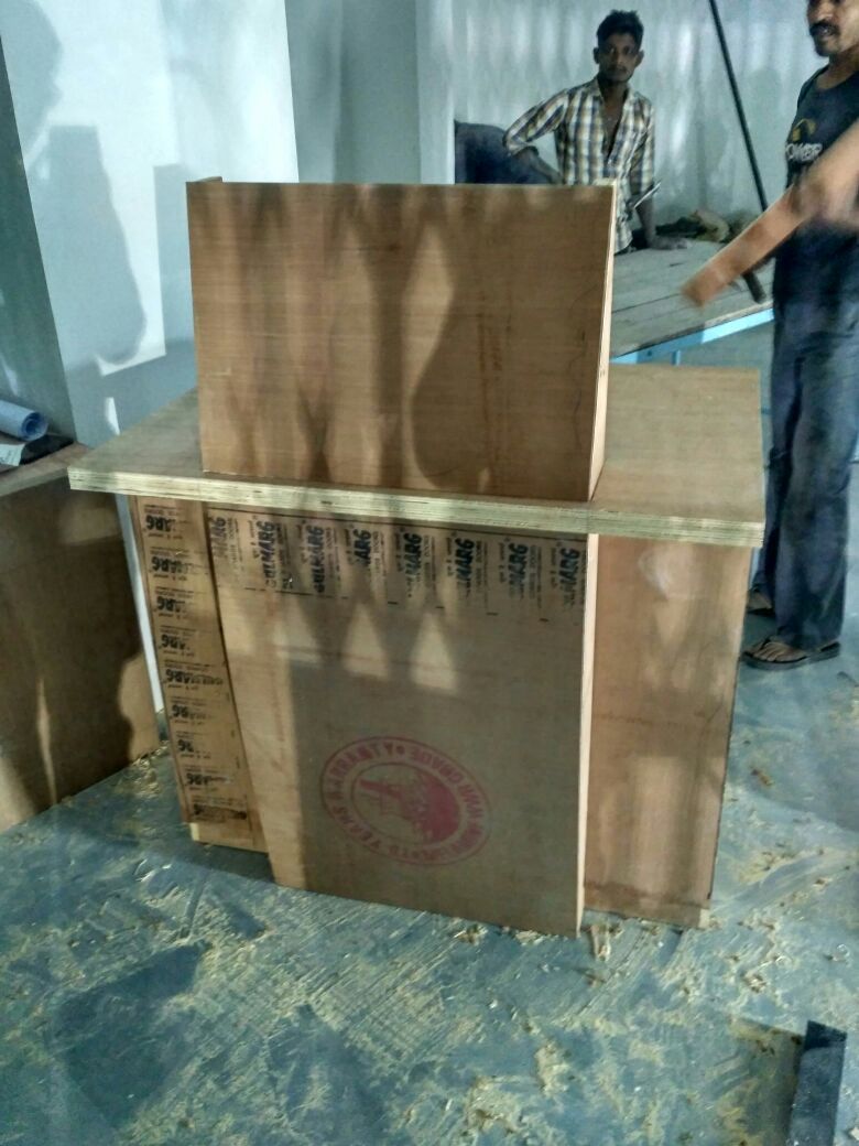 Plywood service counter under fabrication with workers at the Jamnagar site