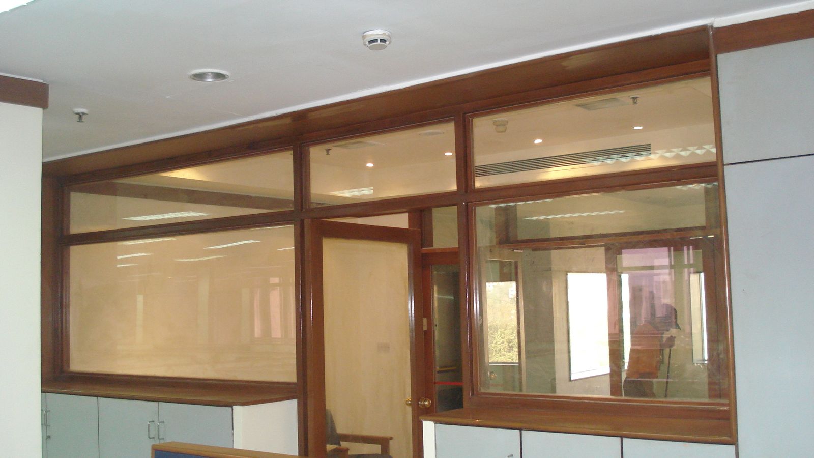 Wood-framed glass partitions with doors on a finished corporate office floor