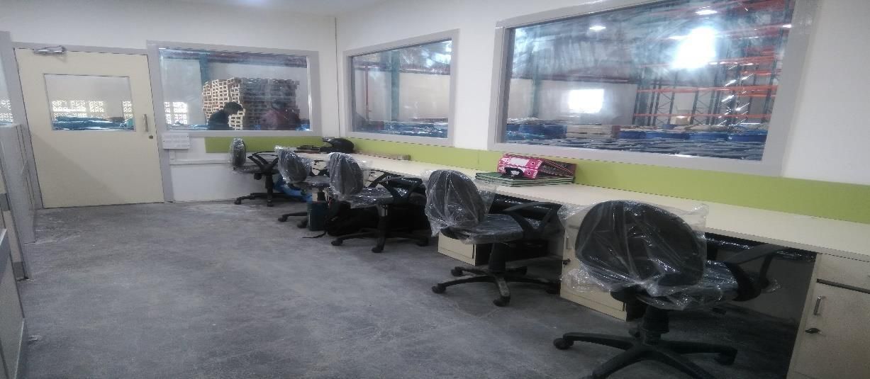 Finished warehouse office interior with workstations and glazed partitions executed by Juveriya Interior Decorator